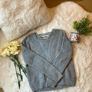 Grey knit sweater with slight drawstring back in women’s small.